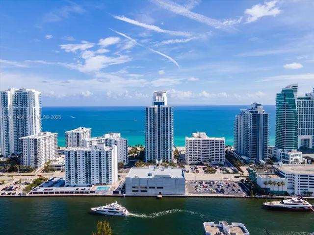 Aerial perspective featuring coastal high-rise architecture, direct water frontage, deep-water access, and horizon ocean scenery