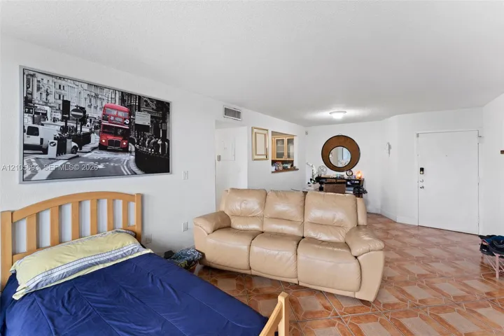 Open-concept interior featuring ceramic tile flooring, neutral wall finishes, and a wall-cutout partition