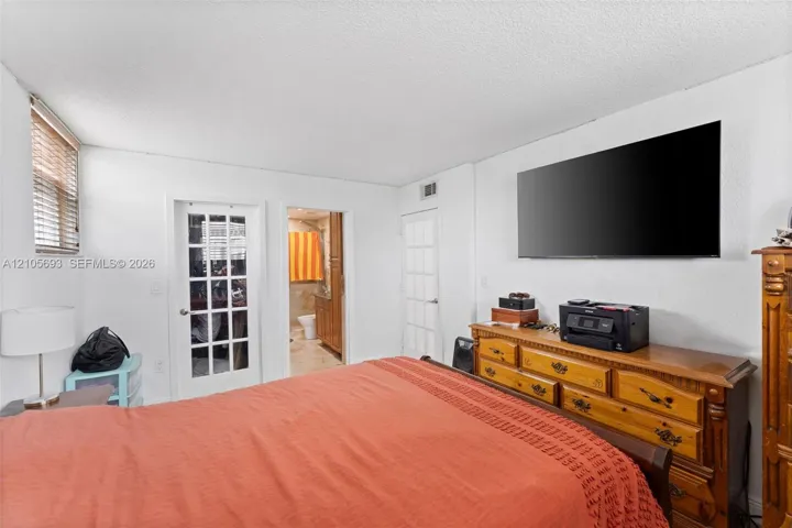 Room interior featuring white walls, two multi-lite glass panel doors, and window blinds