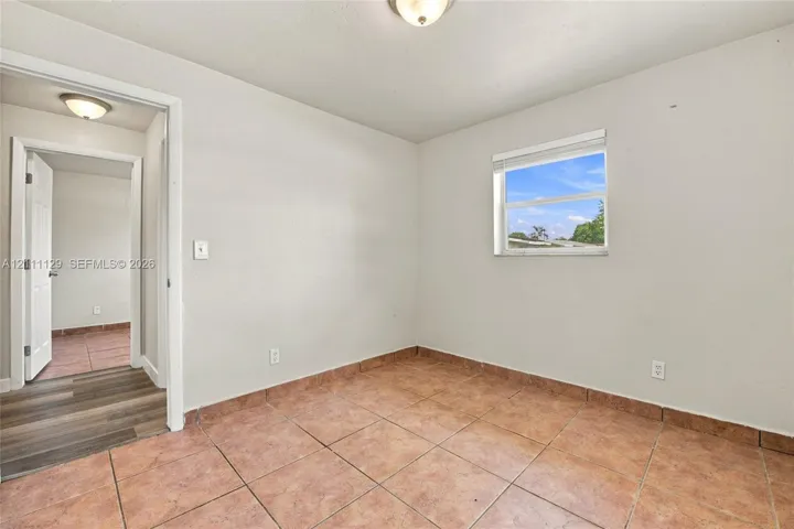 Room featuring ceramic tile flooring, neutral wall paint, and a single-pane window