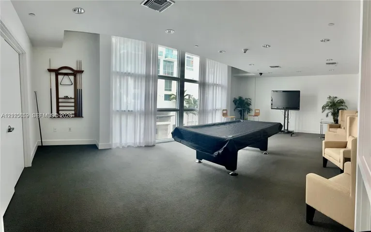 Expansive room featuring floor-to-ceiling windows, recessed lighting, and wall-to-wall carpeting