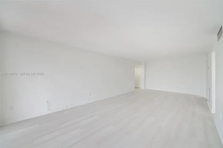 Expansive interior featuring light-toned wood-finish flooring and neutral-painted walls