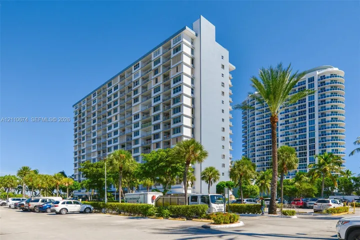 High-rise exterior featuring a multi-story concrete facade with integrated private balconies and floor-to-ceiling glass paneling