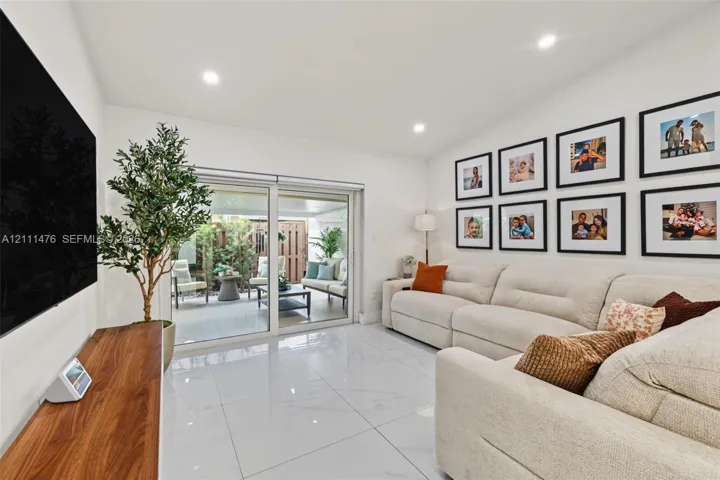 Interior space featuring polished stone-look flooring, recessed lighting, and expansive sliding glass doors