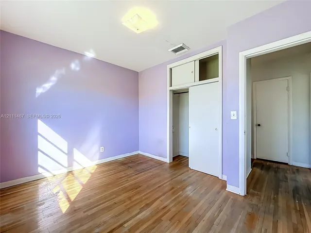 Interior room featuring hardwood flooring, a closet with overhead storage, and a flush-mount ceiling light fixture