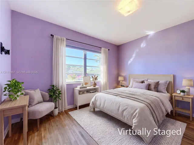 Wood-finish flooring, multi-pane window with horizontal blinds, and flush-mount ceiling light fixture