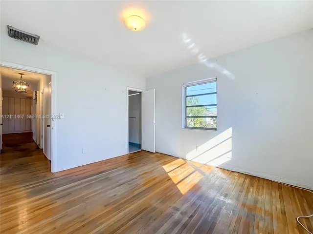 Interior space featuring wood-finish flooring, a multi-pane window, and a central flush-mount ceiling light fixture