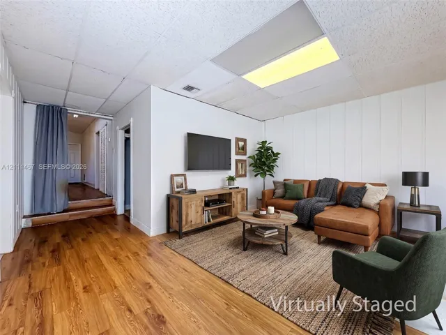 Wood-finish flooring, vertical plank wall paneling, and recessed ceiling lighting