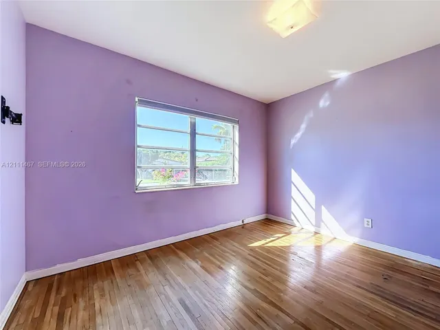 Wood-finish flooring, multi-pane horizontal window, and ceiling-mounted light fixture