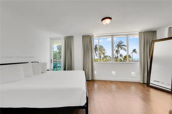 Wood-finish flooring, floor-to-ceiling windows, access to a private balcony, and flush-mount ceiling lighting
