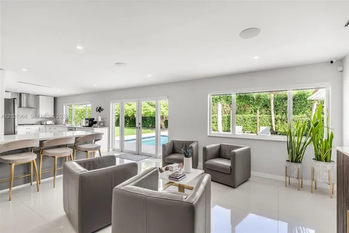 Open-concept interior featuring large-format tile flooring, recessed lighting, and a kitchen island with quartz-style countertop
