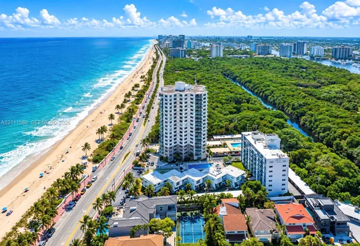 Coastal high-rise residence featuring private outdoor swimming pools, a hard-court tennis facility, and direct proximity to the Atlantic shoreline