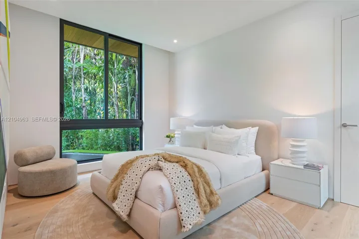Large-format floor-to-ceiling sliding window, wood-finish flooring, and solid-core interior door
