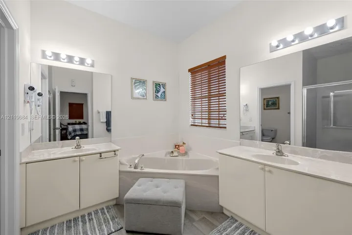 Dual vanities featuring solid-surface countertops, integrated sinks, and polished chrome hardware