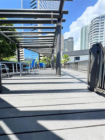 Rooftop terrace featuring wooden decking, a custom pergola, and horizontal-slat railings