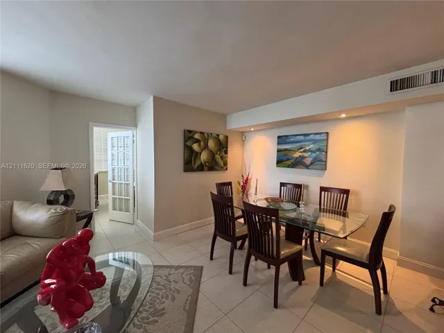 Open-concept interior featuring light-colored tile flooring, recessed ceiling lighting, and a French door with glass panels