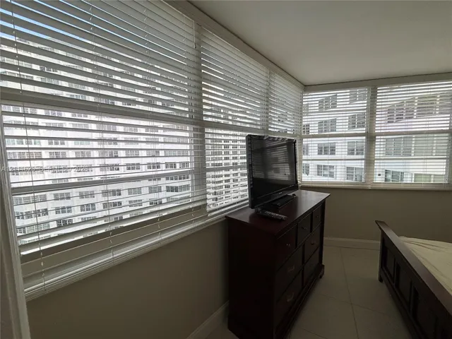 Expansive multi-pane windows featuring horizontal blinds and tile-finish flooring