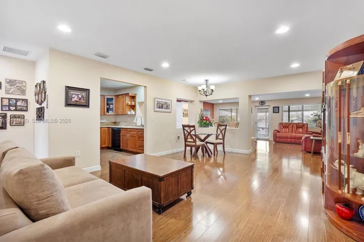 Wood-finish flooring, recessed lighting, chandelier, and built-in wood cabinetry