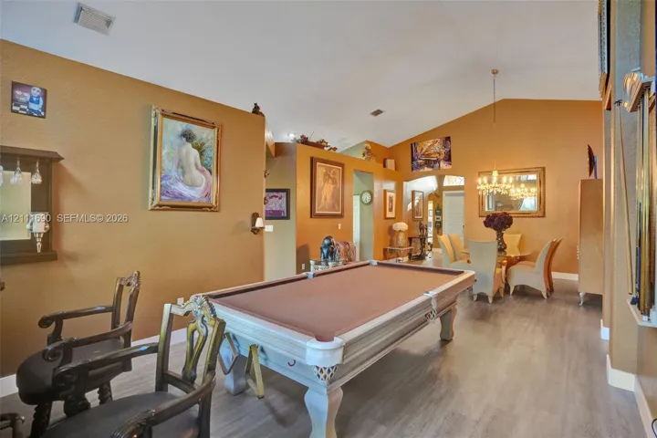 Vaulted ceilings, wood-finish flooring, and a multi-arm chandelier