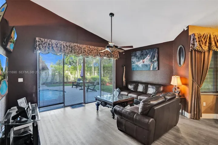 Vaulted ceilings, wood-finish flooring, and sliding glass doors providing outdoor access