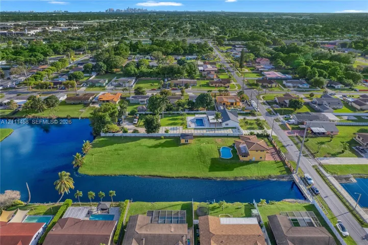 Waterfront lot featuring a private swimming pool, expansive lawn, and perimeter fencing