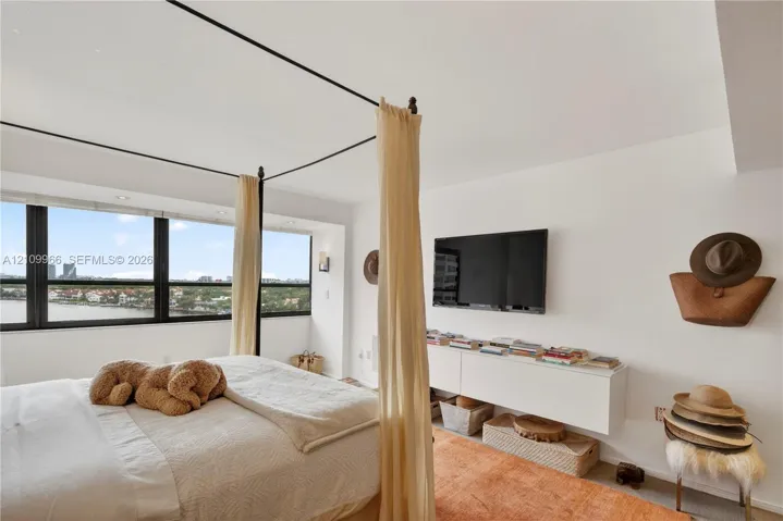 Floor-to-ceiling windows with expansive water scenery, wall-mounted white cabinetry, and recessed lighting