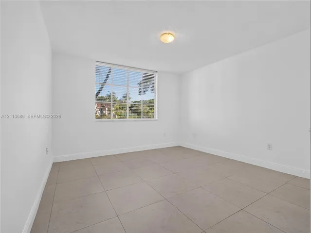 Room featuring large-format ceramic tile flooring, neutral walls, and a multi-pane window