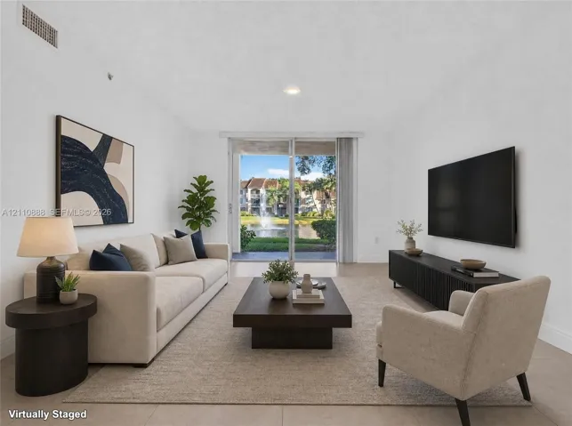 Living area featuring tile flooring, neutral paint, and sliding glass doors opening to an exterior terrace with water scenery