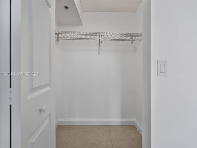 Storage area featuring wire shelving and neutral tile flooring