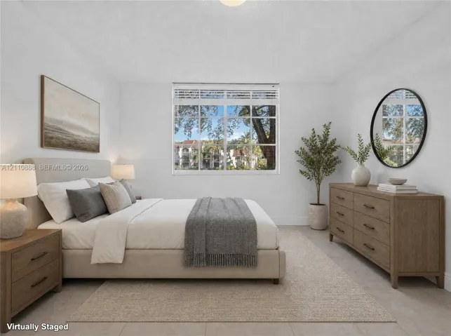 Neutral-toned interior space featuring light-colored tile flooring, crisp white wall finishes, and a single-pane window with white horizontal blinds