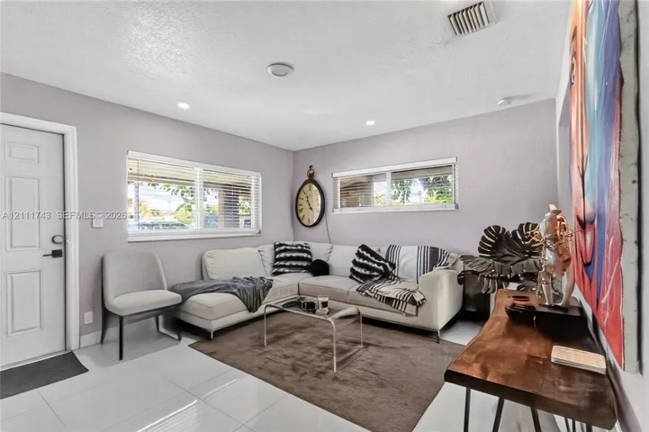 Bright interior featuring large-format ceramic tile flooring, recessed lighting, and horizontal window blinds
