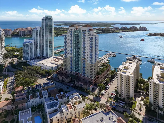 High-rise residential tower featuring a multi-story glass and concrete facade, situated on a waterfront lot with deep-water boat slips and a peripheral parking structure