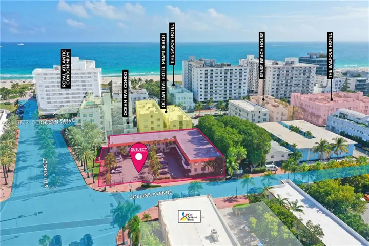 Aerial perspective of the subject property featuring a corner lot location, surface parking area, and mature palm landscaping within the South Beach district