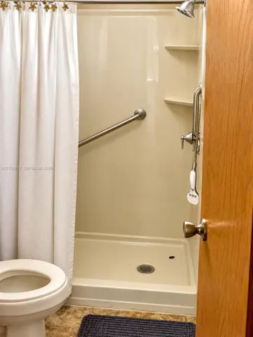 Shower stall with integrated shelving, handheld shower fixture, and wall-mounted metal grab​​‌​​​​‌​​‌‌​‌‌​​​‌‌​‌​‌​‌​​​‌​​ bar