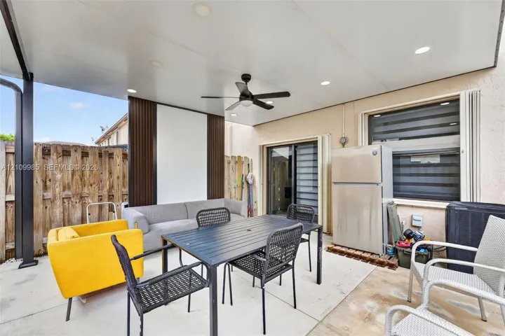 Covered patio featuring a concrete floor, recessed lighting, ceiling fan, and decorative vertical wall panels