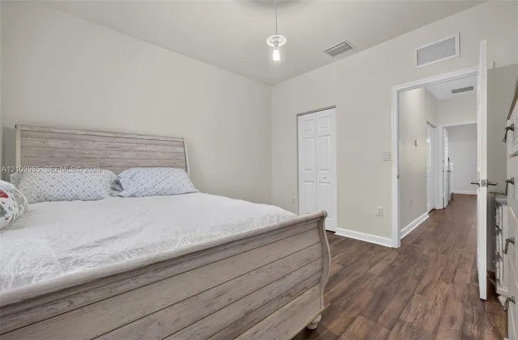 Wood-finish flooring, neutral wall color, and double-panel interior closet doors