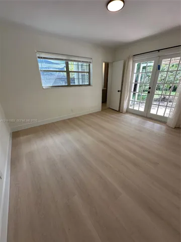 Light-filled interior featuring wood-finish flooring, white walls, and French doors