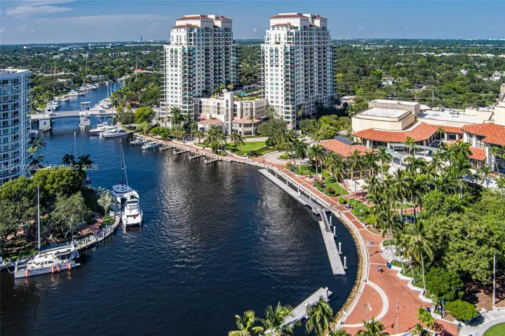 High-rise residential towers featuring deep-water dockage, brick-paved walkways, and established tropical landscaping situated along a waterway