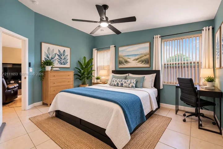 Primary Bedroom featuring tile flooring, dual windows with vertical blinds, and a matte black ceiling fan with integrated lighting
