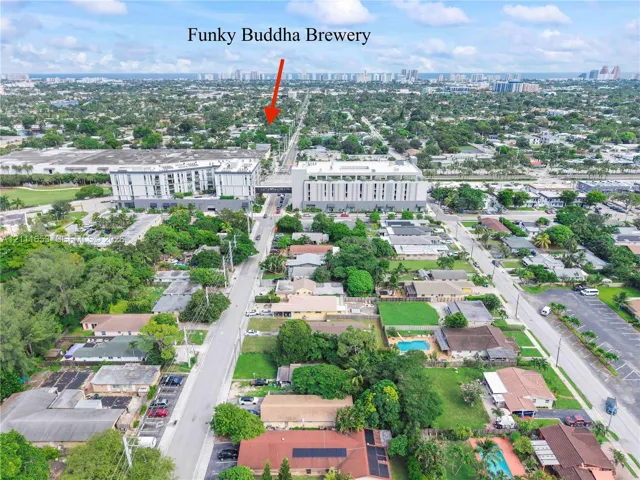 Just a stone's throw from Oakland Park's Funky Buddha Brewery, aerial perspective of the urban neighborhood featuring established tree canopy, paved roadway infrastructure, residential properties