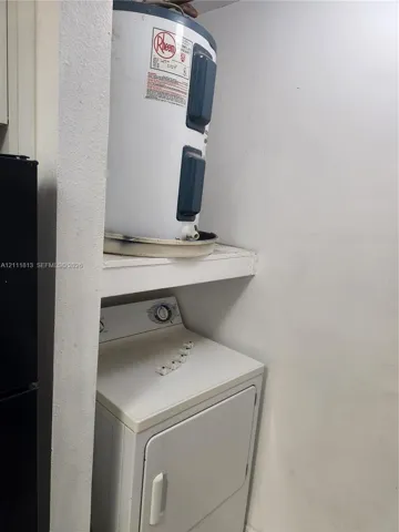 Utility closet containing a water heater and appliance storage space