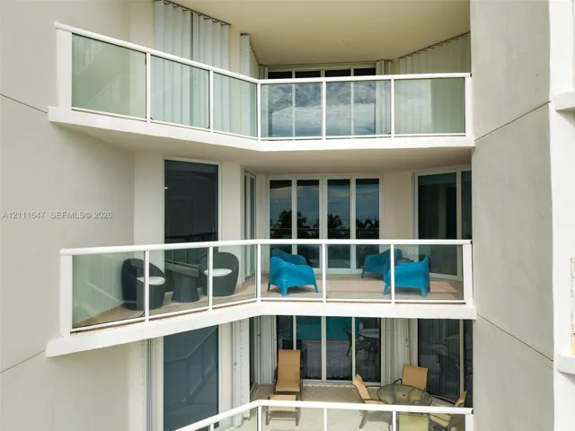 Multi-level stacked balconies featuring glass railings and tile flooring