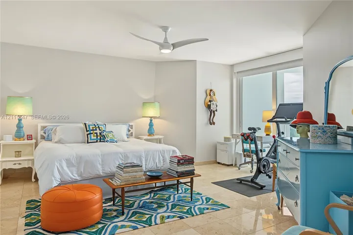 Spacious room featuring polished stone flooring, large floor-to-ceiling windows, and a modern three-blade ceiling fan with integrated lighting
