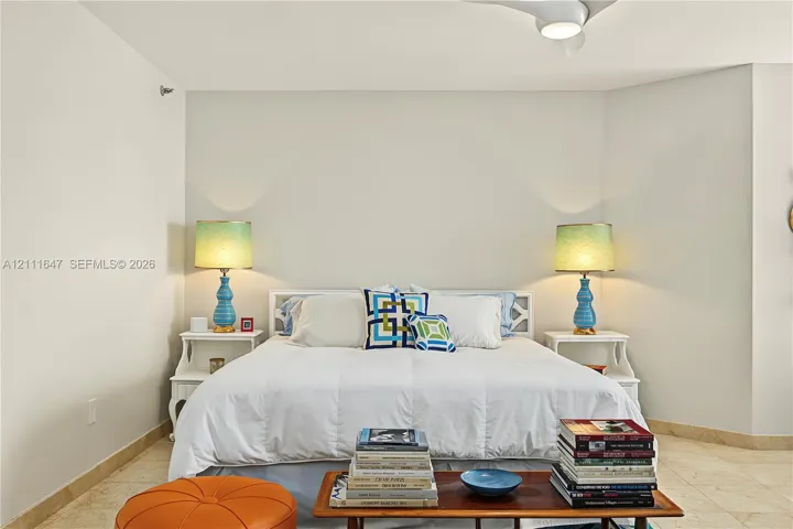 Neutral-toned interior space featuring stone-style flooring and an integrated ceiling fan with light fixture