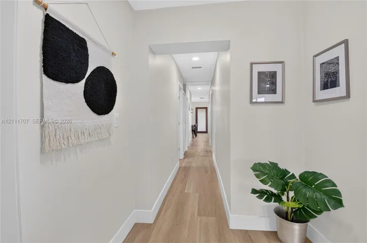 Hallway featuring wood-finish flooring, recessed lighting, and neutral wall tones