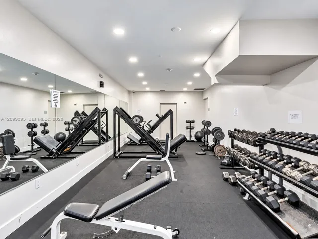 Fitness room featuring recessed lighting, wall-to-wall mirrored surfacing, and resilient rubberized flooring