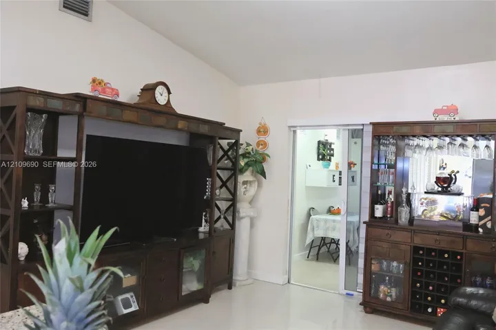 Vaulted ceiling and sliding glass door leading to a separate room