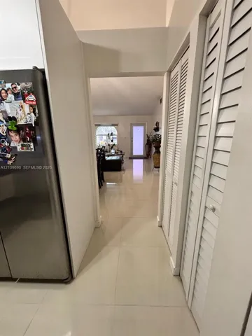 Large-format tile flooring, high ceilings, and floor-to-ceiling louvered-panel closet doors