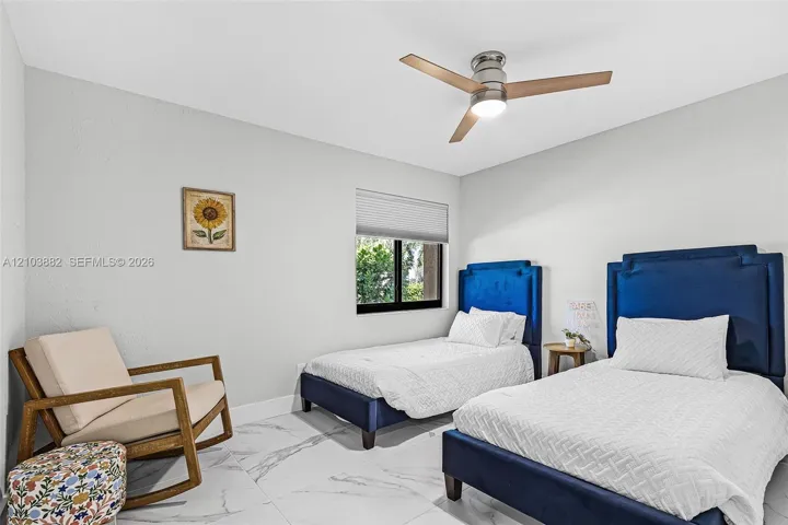 Neutral interior featuring large-format stone-look tile flooring, a modern three-blade ceiling fan with integrated lighting, and a single-hung window with a cellular shade