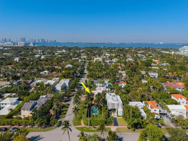 Aerial perspective featuring a private swimming pool, mature palm trees, and manicured perimeter hedging